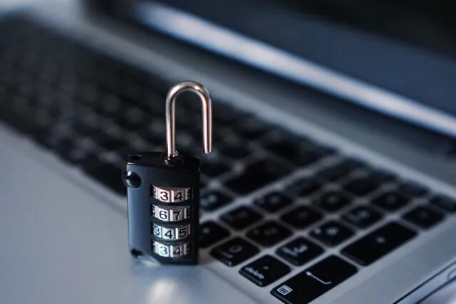 Laptop cu ecran de autentificare și o cheie de securitate lângă el